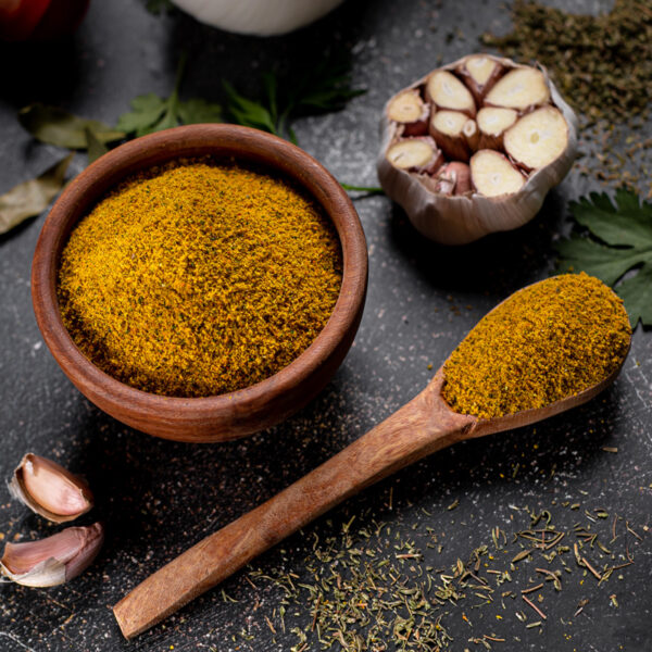 Chicken Boullion Powder in a spoon and a bowl with complements